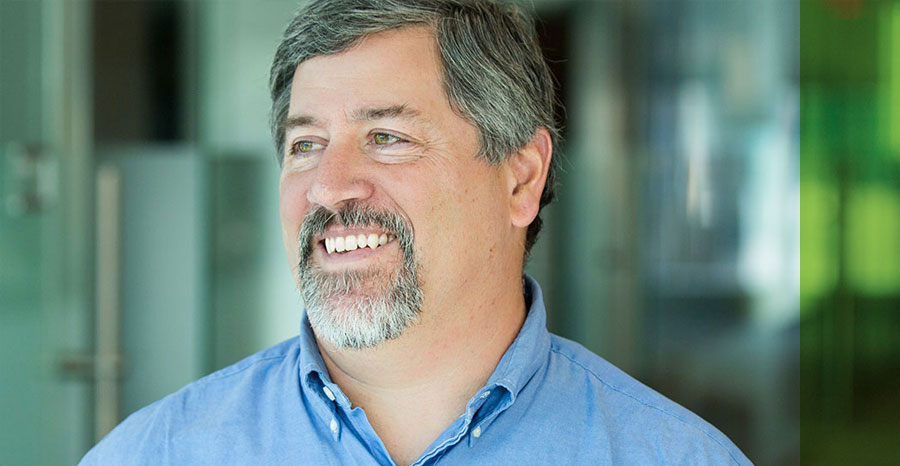 Bearded man in a blue shirt and a smiling face