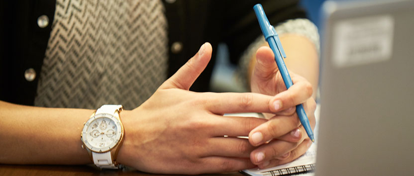 A pair of hands resting on an office desk