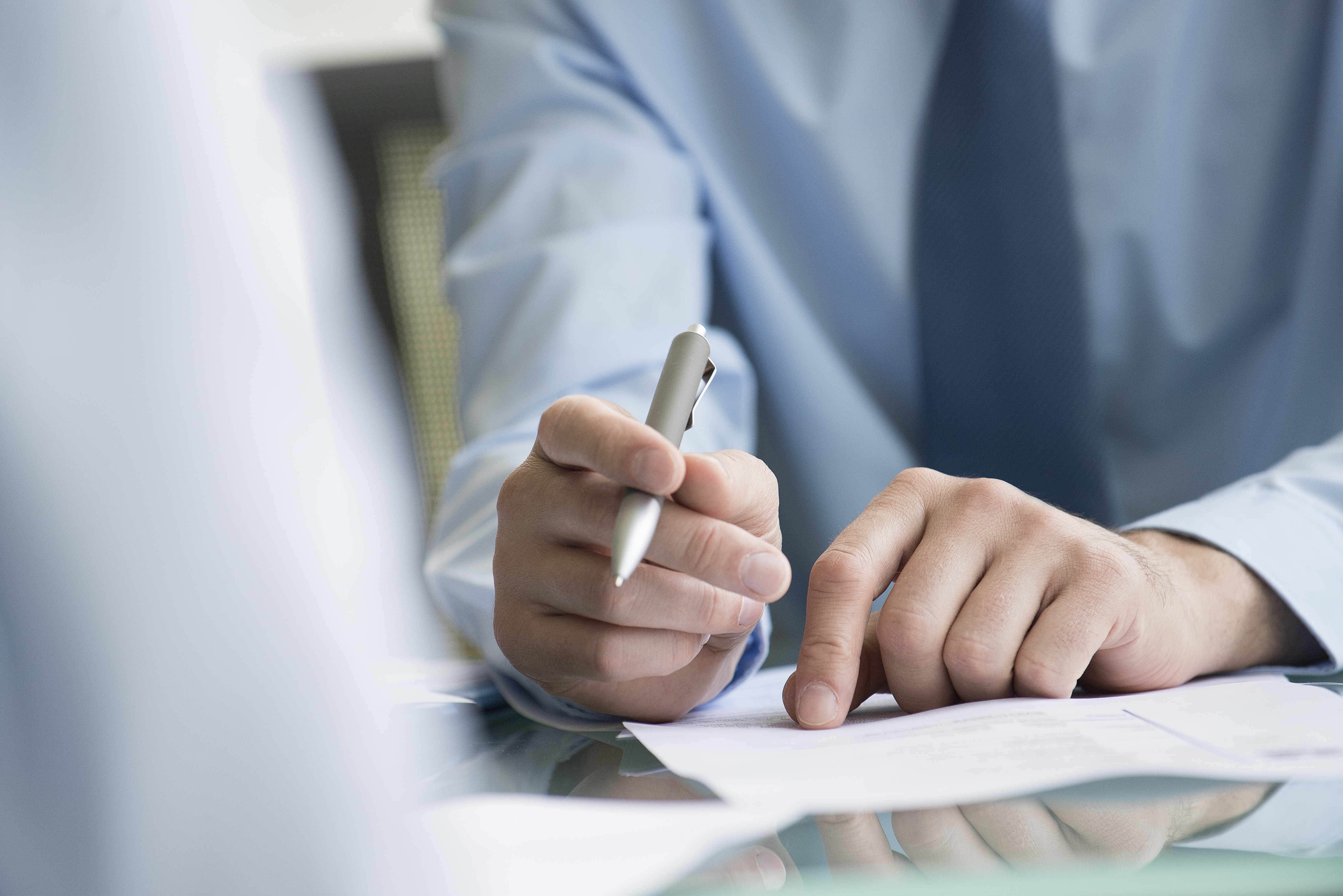 Man jotting down the points on a paper in a meeting room