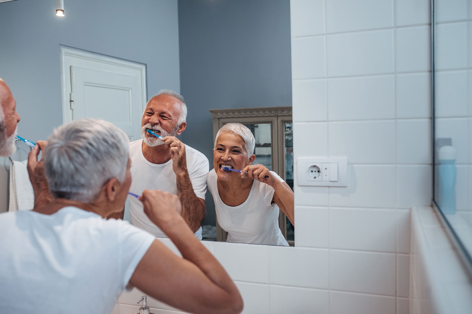 Silver couple brushing teeth