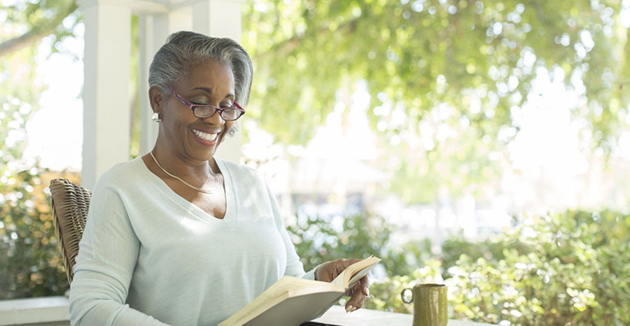 Elderly woman smiling as she reads a book