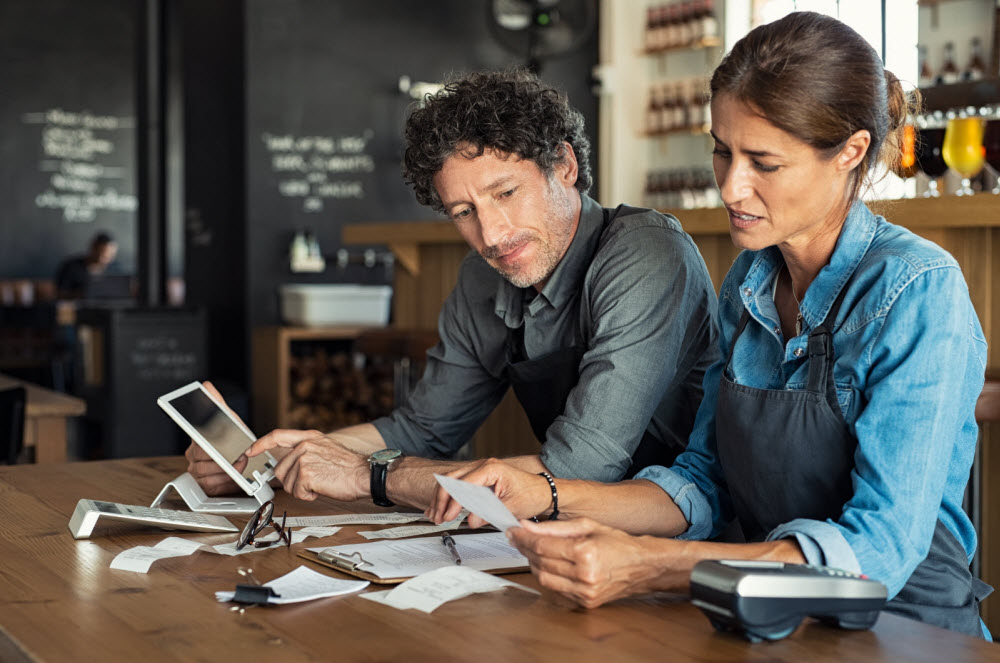 Two coworkers going through a list at a desk