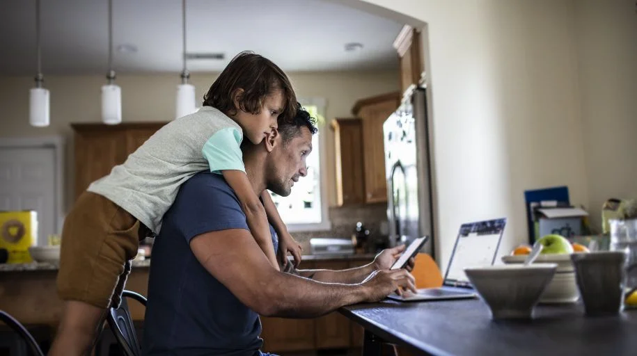 Man working from home while spending time with child